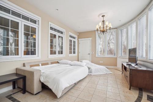 a bedroom with a bed and a desk and windows at Villa Laval Bord de l'eau in Laval
