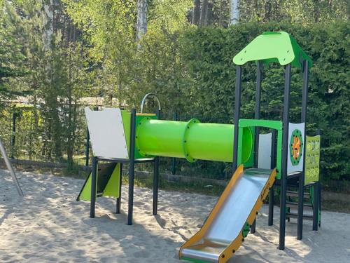 einen Spielplatz mit Rutsche im Sand in der Unterkunft Apartamenty Silence Baltic Indygo in Pobierowo