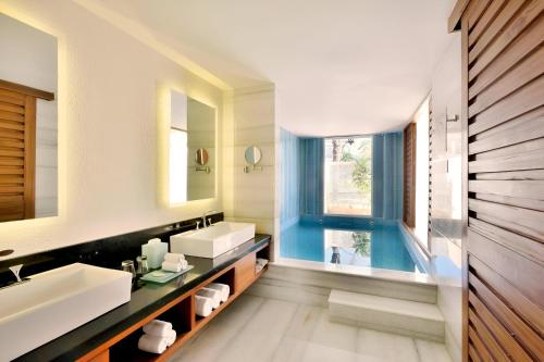 a bathroom with two sinks and a swimming pool at The Westin Pushkar Resort & Spa in Pushkar