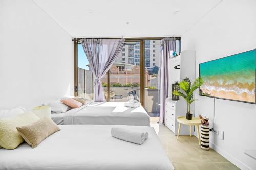 two beds in a room with a large window at Arthur's Hotel Bondi Junction in Sydney