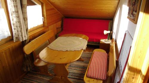 um pequeno quarto com uma mesa e um banco numa pequena casa em Gästehaus Erlhof em Schiefling am See