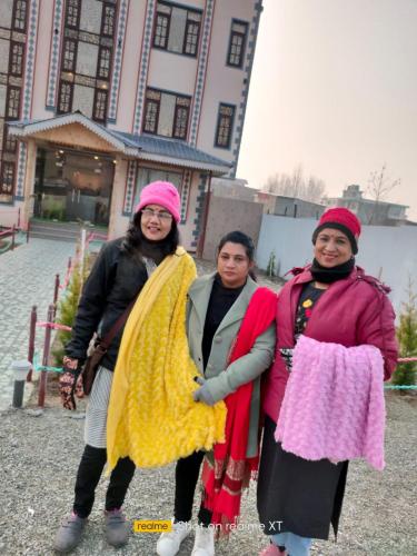 eine Gruppe von drei Frauen, die vor einem Gebäude stehen in der Unterkunft Golden Eye in Srinagar