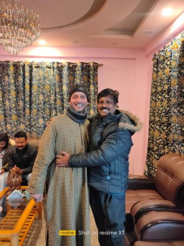 Zwei Männer, die sich für ein Bild in einem Wohnzimmer ausgaben in der Unterkunft Golden Eye in Srinagar