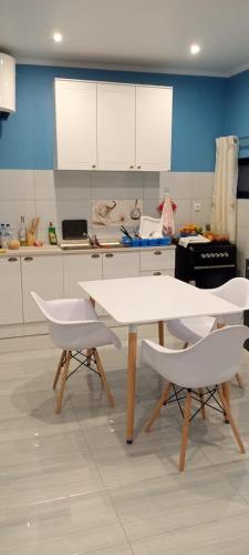 a kitchen with a white table and two white chairs at Katembe beach view in Maputo