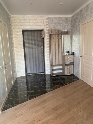 ein leeres Zimmer mit einer Tür und einem Spiegel in der Unterkunft Евродвушка в новостройке in Qaraghandy