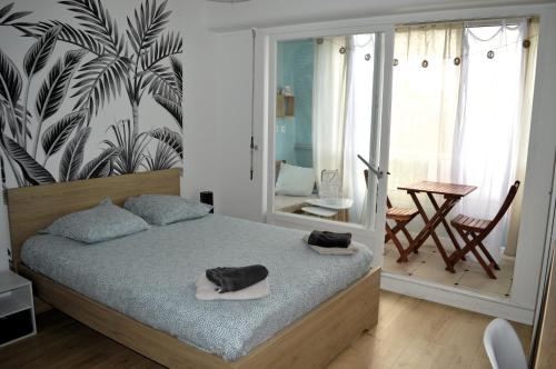 Un dormitorio con una cama con dos toallas encima. en Le levant - avec loggia - à 20m de la plage, en Courseulles-sur-Mer