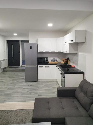 a kitchen with white cabinets and a refrigerator at Comfort Stay, EV, Parking in Bolesławiec