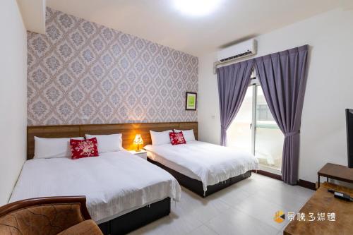 una camera d'albergo con due letti e una finestra di Shi Mom B&B a Città di Hualien