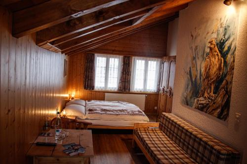 - une chambre avec un lit et une peinture murale dans l'établissement Pension Sonne, à Adelboden