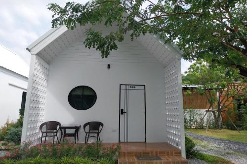 a white shed with four chairs in it at It my life cafe x camp in Ban Tha Sai