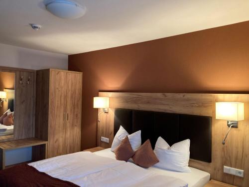 1 dormitorio con 1 cama grande con sábanas y almohadas blancas en Landgasthof Meja, en Radibor
