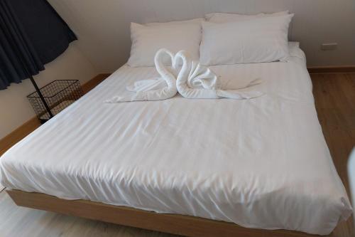 a white bed with two swans on it at It my life cafe x camp in Ban Tha Sai