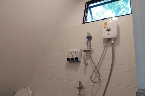 La salle de bains est pourvue d'une douche et d'une fenêtre. dans l'établissement It my life cafe x camp, à Ban Tha Sai