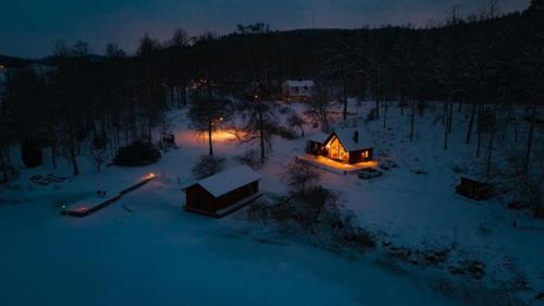 a house is lit up in the snow at night at Lovely house on beautiful private lakeside estate! in Bunn