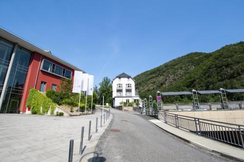 a street in front of a building with a mountain at Haus Alleegarten in Bad Bertrich