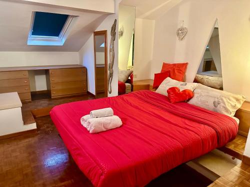 a bedroom with a red bed with two towels on it at L'Attichetto con aria condizionata-Centro Velletri in Velletri