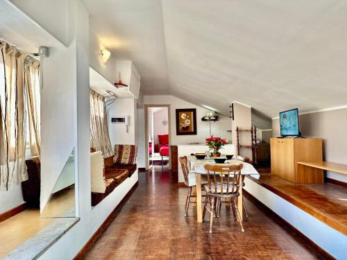 a living room and dining room with a table and chairs at L'Attichetto con aria condizionata-Centro Velletri in Velletri
