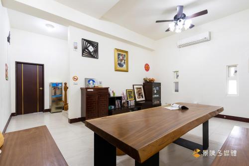 un soggiorno con un tavolo e un ventilatore a soffitto di Shi Mom B&B a Città di Hualien
