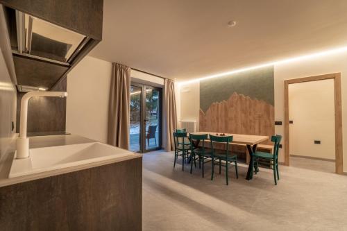 a kitchen and dining room with a table and chairs at Residence Piz Aot in Mezzana