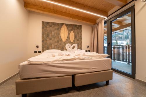 a bed in a room with a large window at Residence Piz Aot in Mezzana