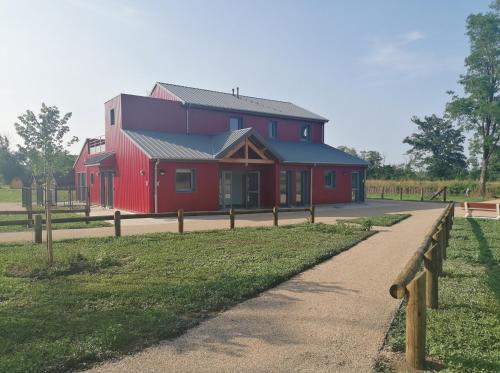 a red building with a path in front of it at La Halte du Canal in Luthenay-Uxeloup