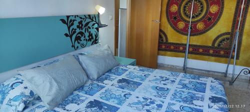 een slaapkamer met een bed met een blauwe en witte quilt bij Apartamento Luminoso el Morche in Morche