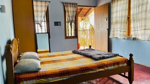 a bedroom with a bed in a room with windows at Manshore bay in Kannur