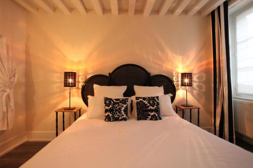 ein Schlafzimmer mit einem großen weißen Bett mit zwei Lampen in der Unterkunft La Berjotine - Maison d'hôtes in Charolles