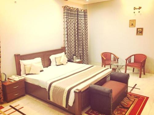 1 dormitorio con 1 cama, 1 silla y 1 mesa en Angel NRI House en Greater Noida