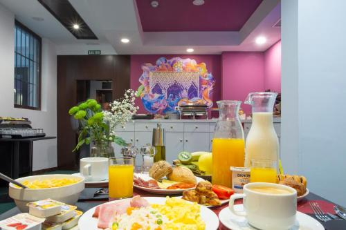 einen Frühstückstisch mit Frühstückszutaten und Orangensaft in der Unterkunft Casual Ilbira Granada in Granada