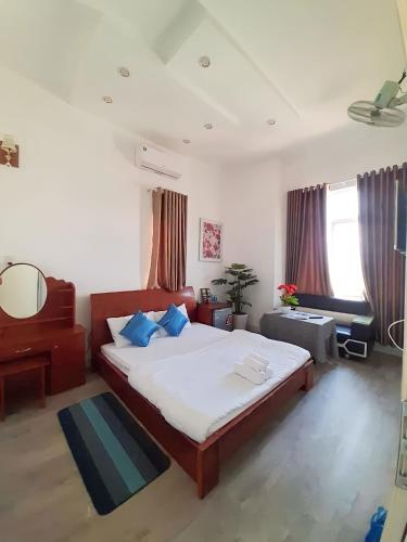 a bedroom with a bed and a desk and a couch at D'Villa Hotel - Homestay in Kon Tum