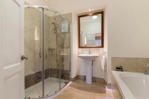 a bathroom with a shower and a sink and a tub at Caldey Island View - Sea Views and Log Burner in Penally
