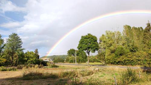 un arco iris sobre un campo con una carretera en BreakyWell, 