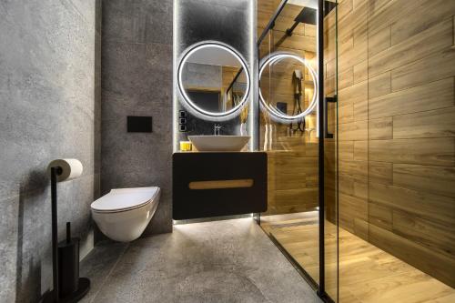 W łazience znajduje się umywalka, toaleta i lustro. w obiekcie Central Park Red Apartment we Wrocławiu