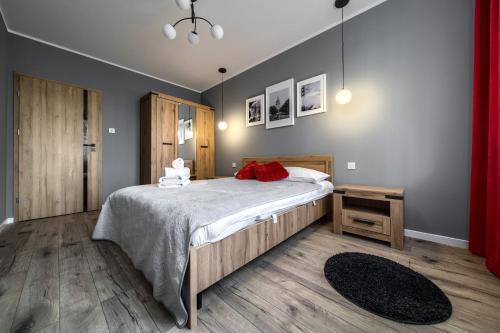 ein Schlafzimmer mit einem Bett mit einem roten Kissen darauf in der Unterkunft Central Park Red Apartment in Breslau