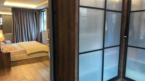 Schlafzimmer mit einem Bett und einer Glasschiebetür in der Unterkunft Permai Oasis in Tanjung Bungah