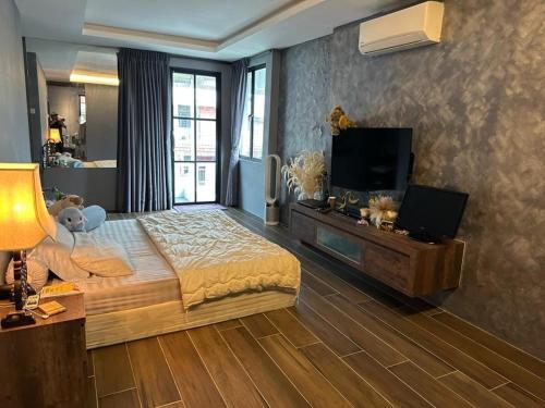ein Schlafzimmer mit einem großen Bett und einem Flachbild-TV in der Unterkunft Permai Oasis in Tanjung Bungah