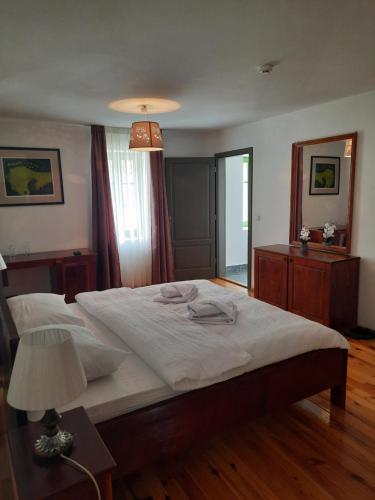a bedroom with a large white bed and a lamp at Turistički centar Andrićgrad in Višegrad