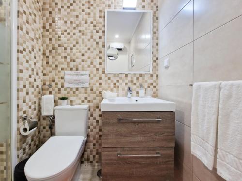 ポルティマンにあるEstúdio Praia da Rocha Peachyのバスルーム(トイレ、洗面台、鏡付)