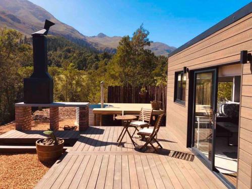 a wooden deck with a table and a stove at Luxury cabin in the Swellendam valley, W.C. in Swellendam