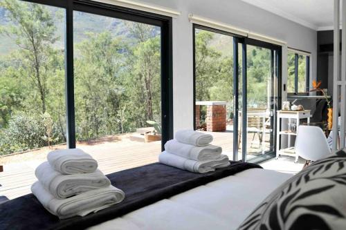 a bedroom with a bed with white towels on it at Luxury cabin in the Swellendam valley, W.C. in Swellendam