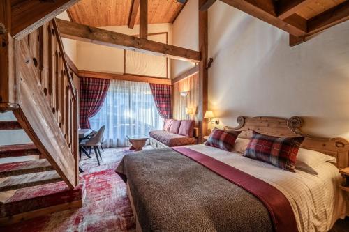 a bedroom with a bed and a staircase in a room at Hotel Le Samoyede in Morzine