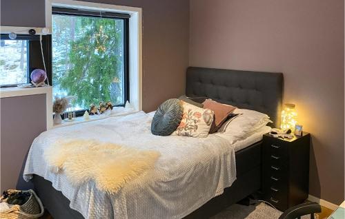 una camera da letto con un letto con una coperta bianca e una finestra di Nice Home In Vrmd With Kitchen a Värmdö