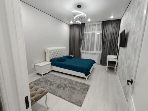 a bedroom with a bed with a blue blanket at ЖК Бухар Жырау in Astana