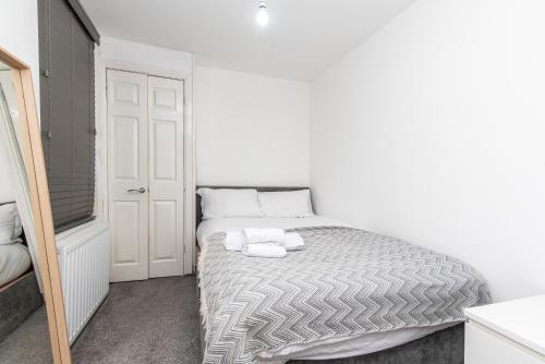 a white bedroom with a bed with towels on it at 1-BR Gem in Sheffield - Easy City Centre Access in Sheffield