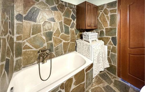 a bath tub in a bathroom with a stone wall at Nice Home In Ypati Lamia With Wi-fi in Ipáti