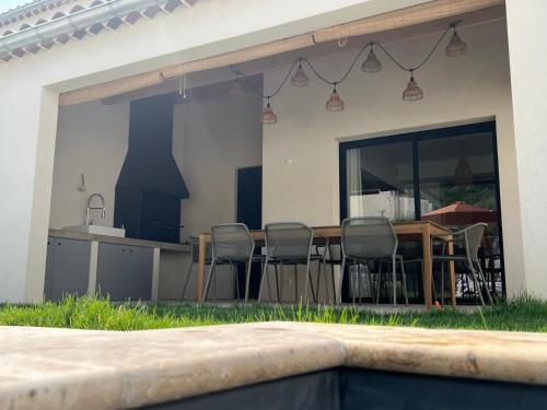 eine Terrasse mit einem Tisch und Stühlen sowie eine Küche in der Unterkunft Villa Hélène in Malaucène