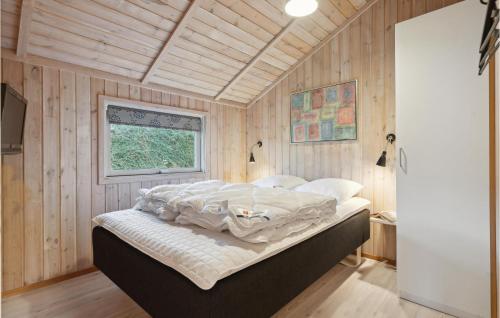 1 dormitorio con 1 cama en una habitación con paredes de madera en Stunning Home In Juelsminde With Sauna en Sønderby