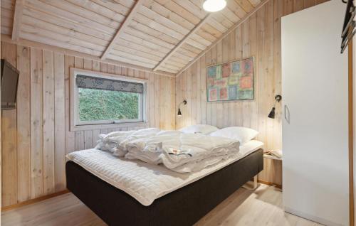 SønderbyにあるStunning Home In Juelsminde With 4 Bedrooms, Sauna And Wifiの木製の壁のベッドルーム1室(ベッド1台付)