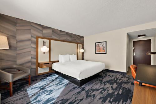 a hotel room with a bed and a chair at Fairfield by Marriott Chesapeake in Chesapeake